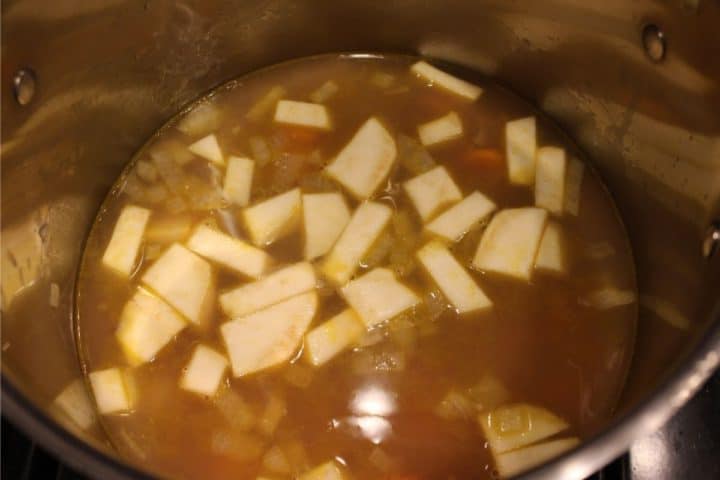 A large pot with vegetables and bone broth. 