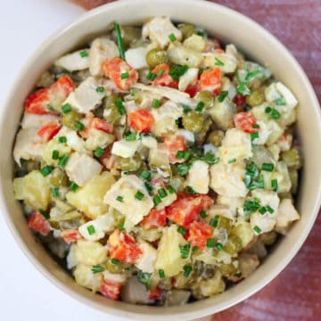 Over head shot of Olivier salad served inn a large white bowl.