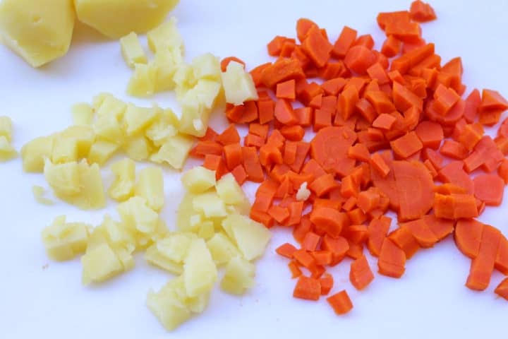 cubed carrots and potatoes on a cutting board