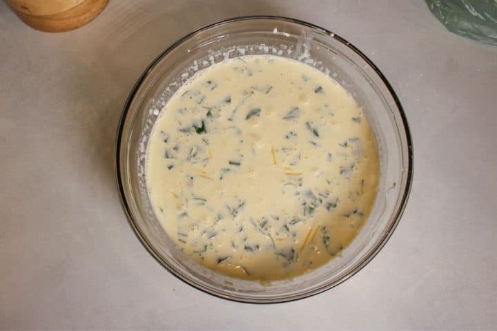 White sauce in a glass mixing bowl.