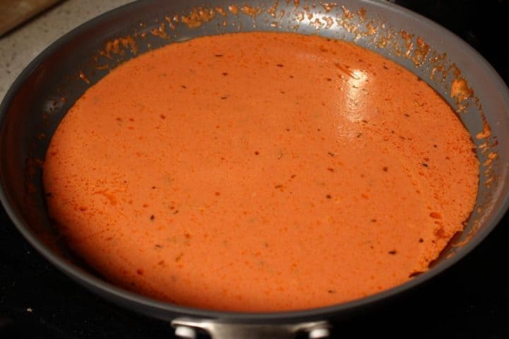 A frying pan with creamy tomato sauce in it.