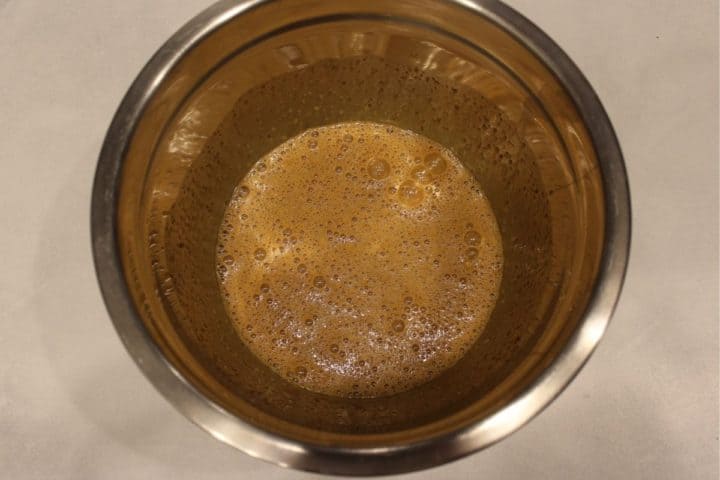 Large mixing bowl with bitten brown sugar and eggs.