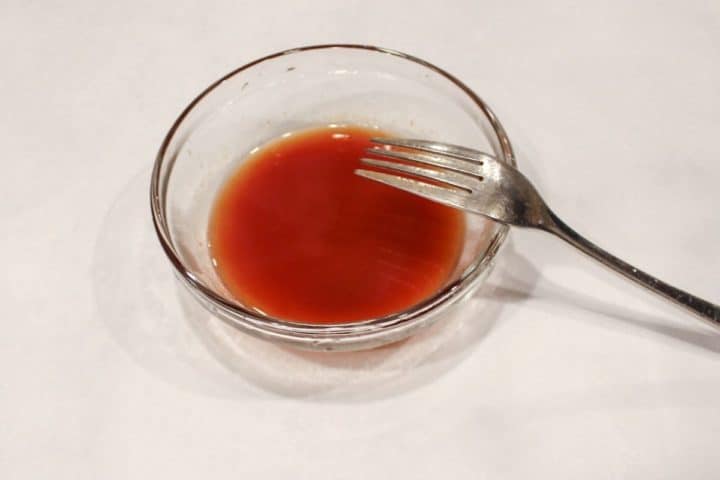 Small glass bowl with hot water and tomato paste.