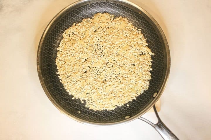 Process shot: pan with uncooked barley and onions with some olive oil. 