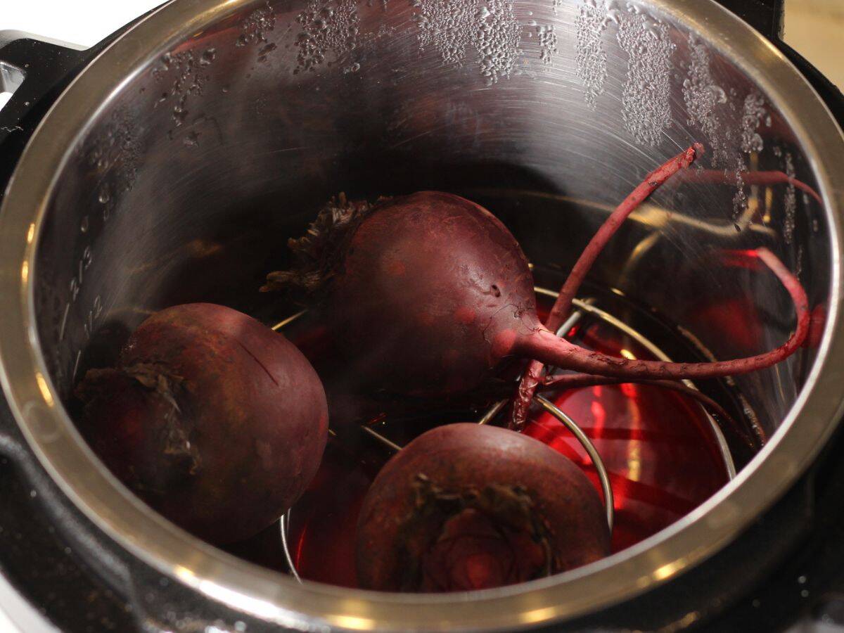 Three pressure cooked whole beets in Instant pot on top of the trivet.