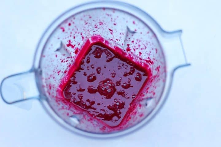 Overhead shot of vitamix mitcher with blended beetroot, milk, eggs and agave nectar.