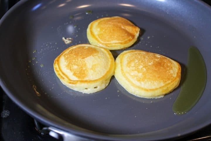 Process shot #5: a frying pan with cooked 3 pancakes on it.