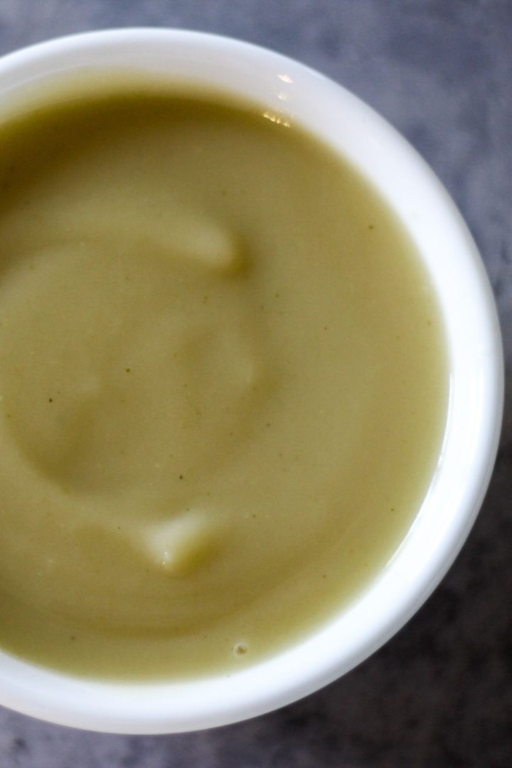 Potato and leek soup in a white bowl.