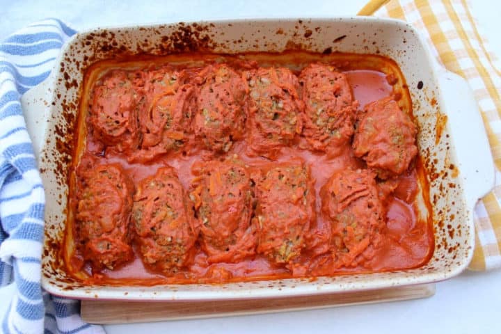 A baking pan with unstuffed cabbage rolls in a tomato sauce. 
