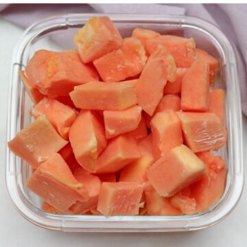 Frozen orange cubed fruit in a glass square container.