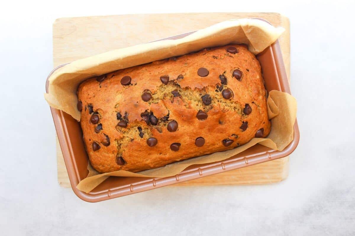 Overhead view of a baked loaf in a baking pan.