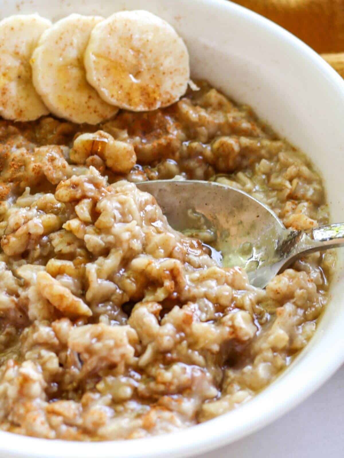 Close-up shot of a spoon scooping creamy oats.