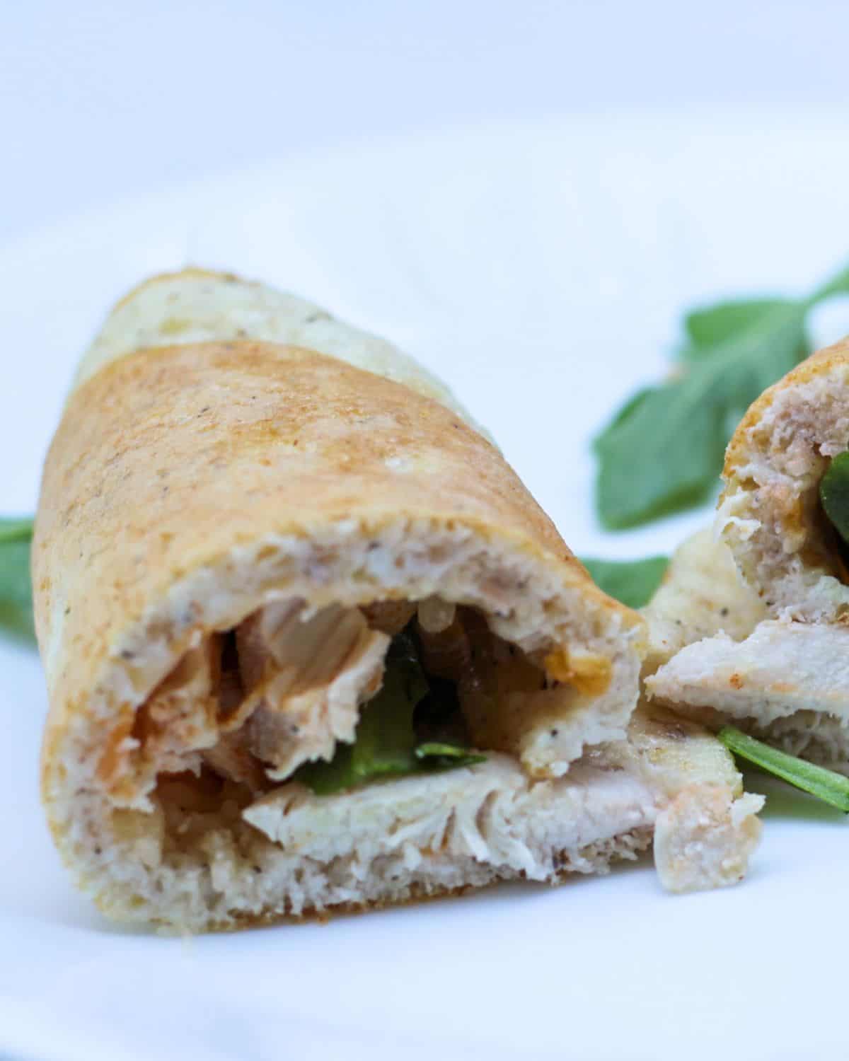 A rolled up chicken in a white wrap.