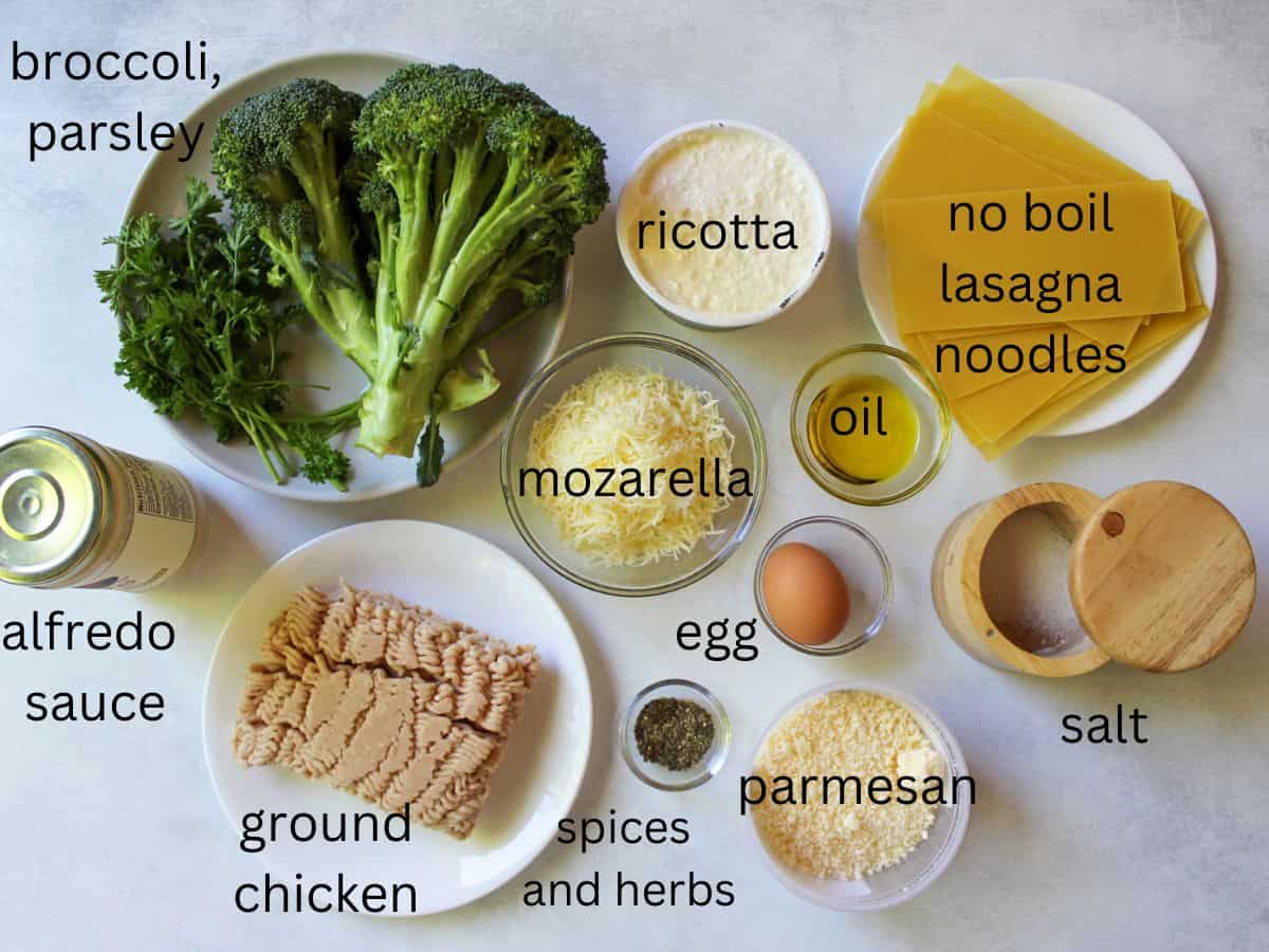 Labeled chicken and broccoli lasagna ingredients in a white surface.