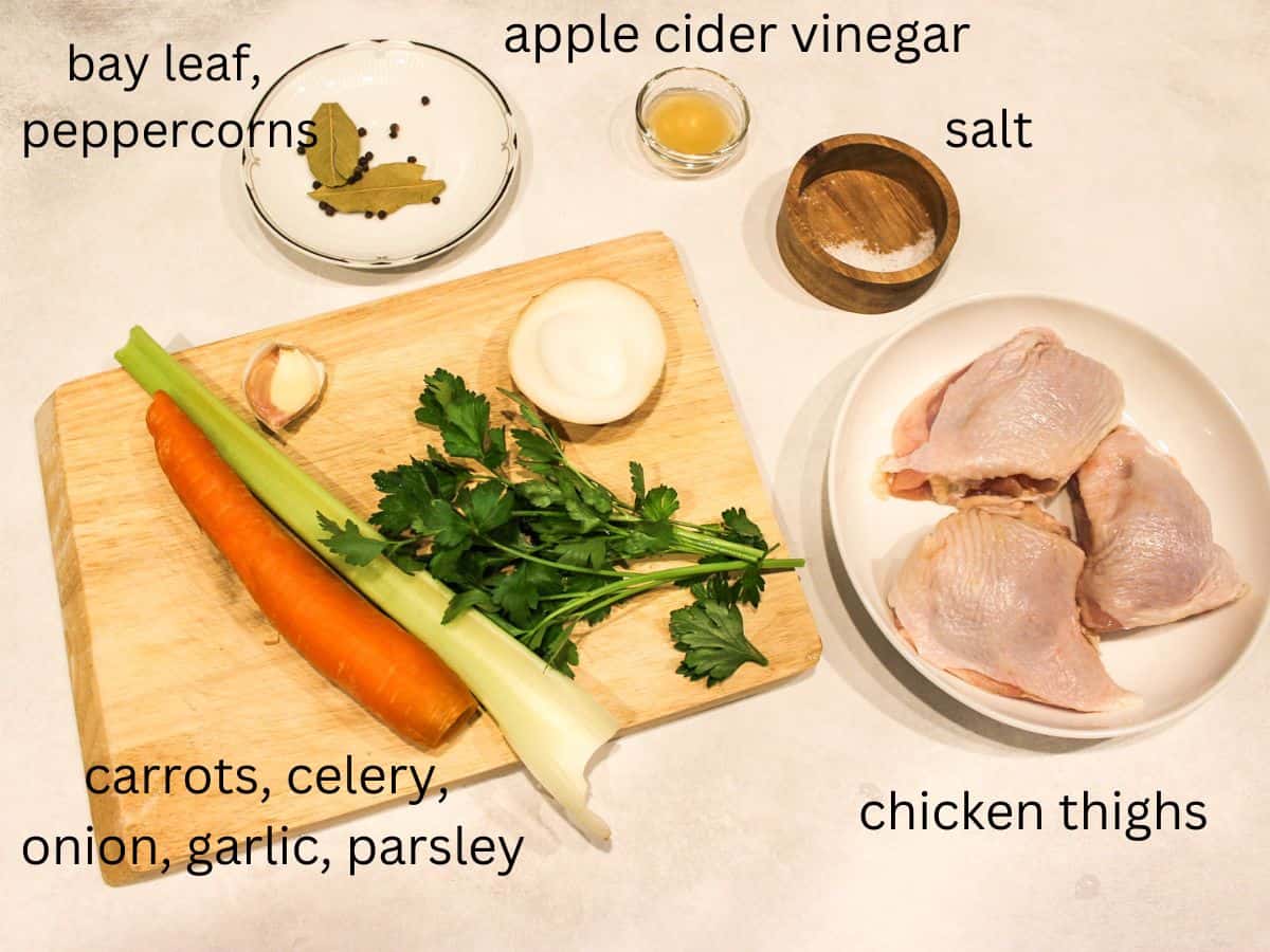 Chicken thigh broth recipe ingredients on a white background. Every ingredient is labeled with the corresponding name.