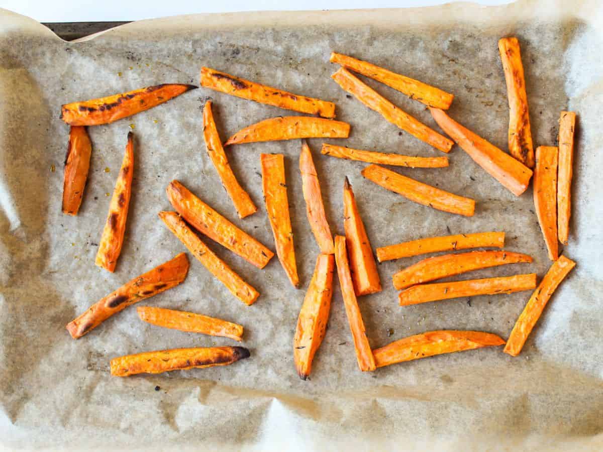 Cooked orange fries arranged on parchment paper without touching.