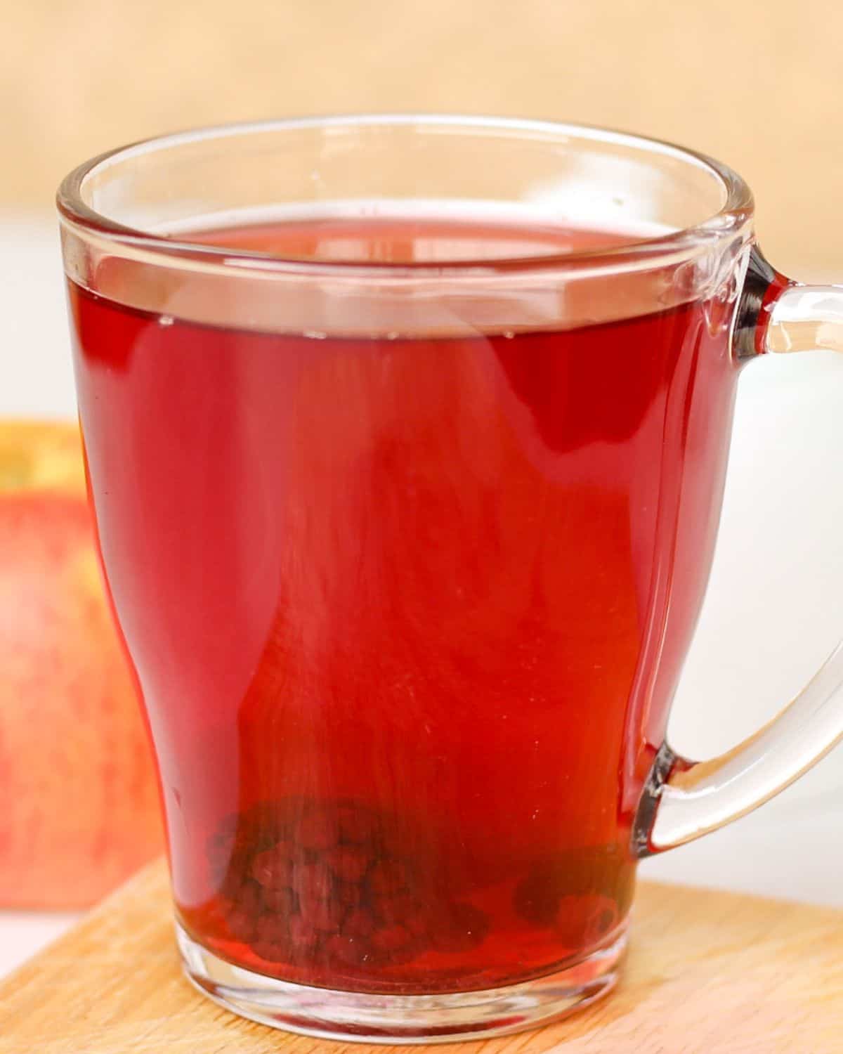 A clear glass cup with kompot fruit drink.