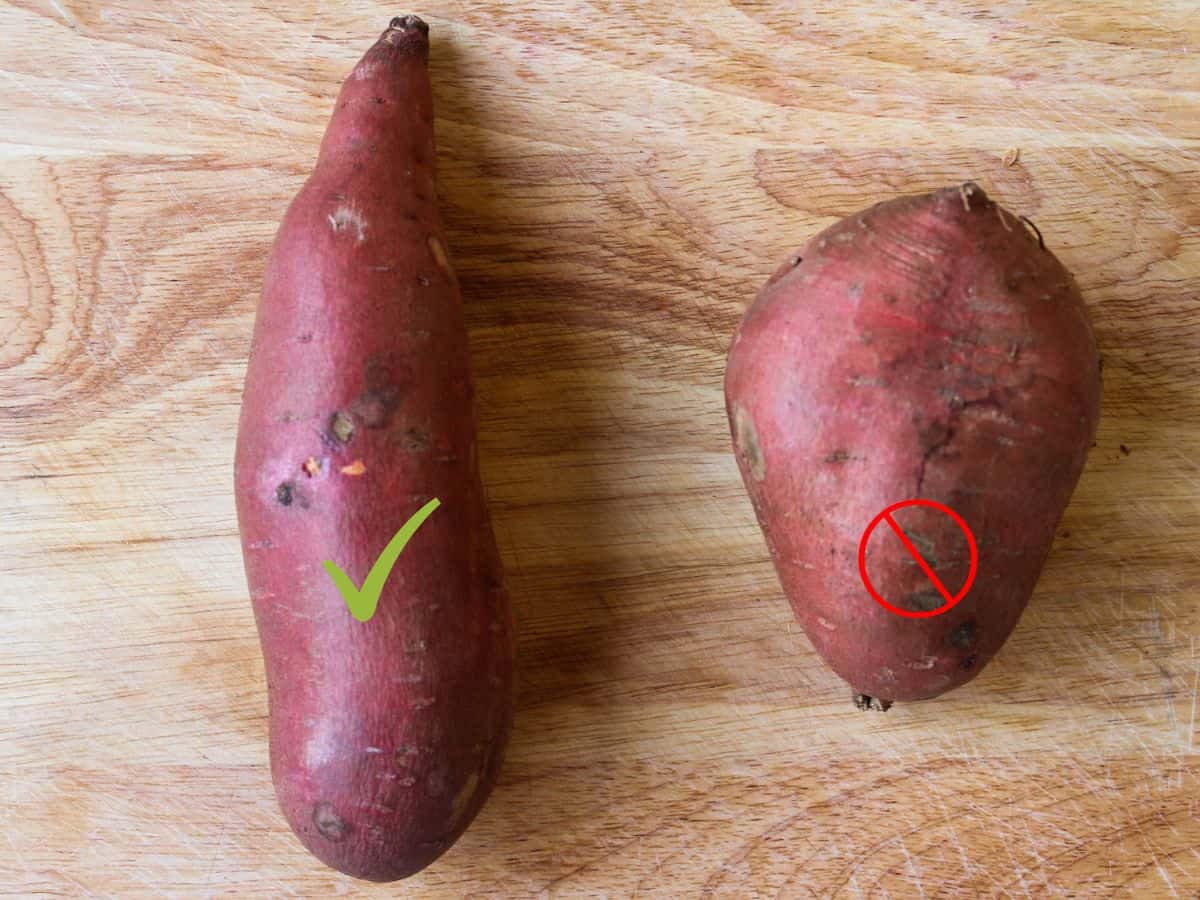 Two sweet potatoes are on a cutting board. On the left there is a longer potato with a green check mark and on the left - wider and smaller potato with a red red crossed out circle.