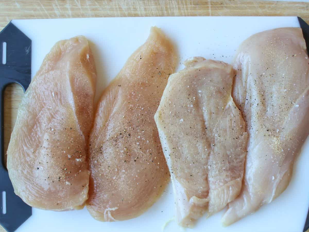 4 uncooked chicken cutlets seasoned with salt and pepper.