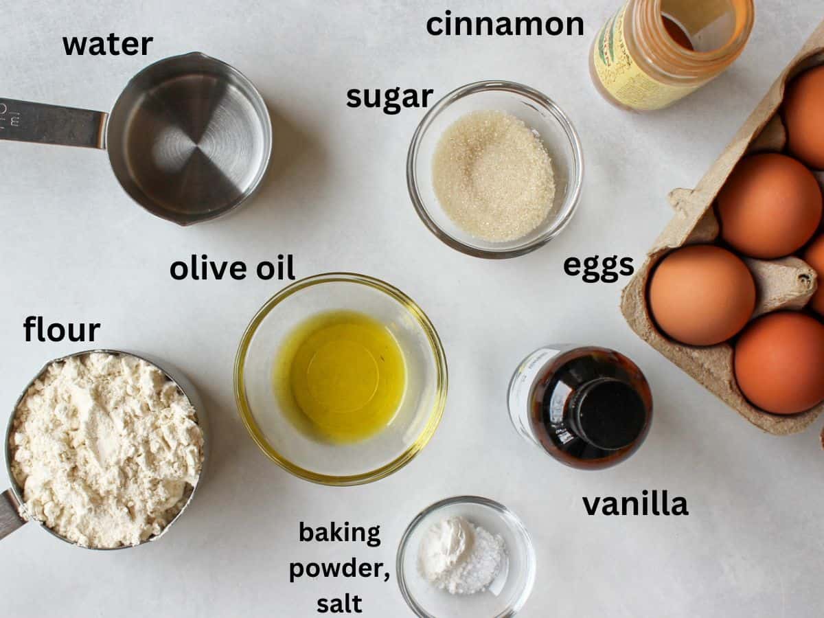 Recipe labeled ingredients on a white background: water, sugar, cinnamon, olive oil, flour, baking powder, salt, vanilla, eggs.