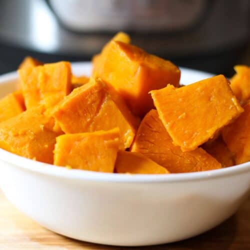Steamed sweet potato cubes in a white bowl.
