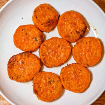 Roasted sweet potato rounds on a white plate.