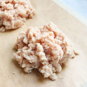 A pile of finely minced chicken on a parchment paper.