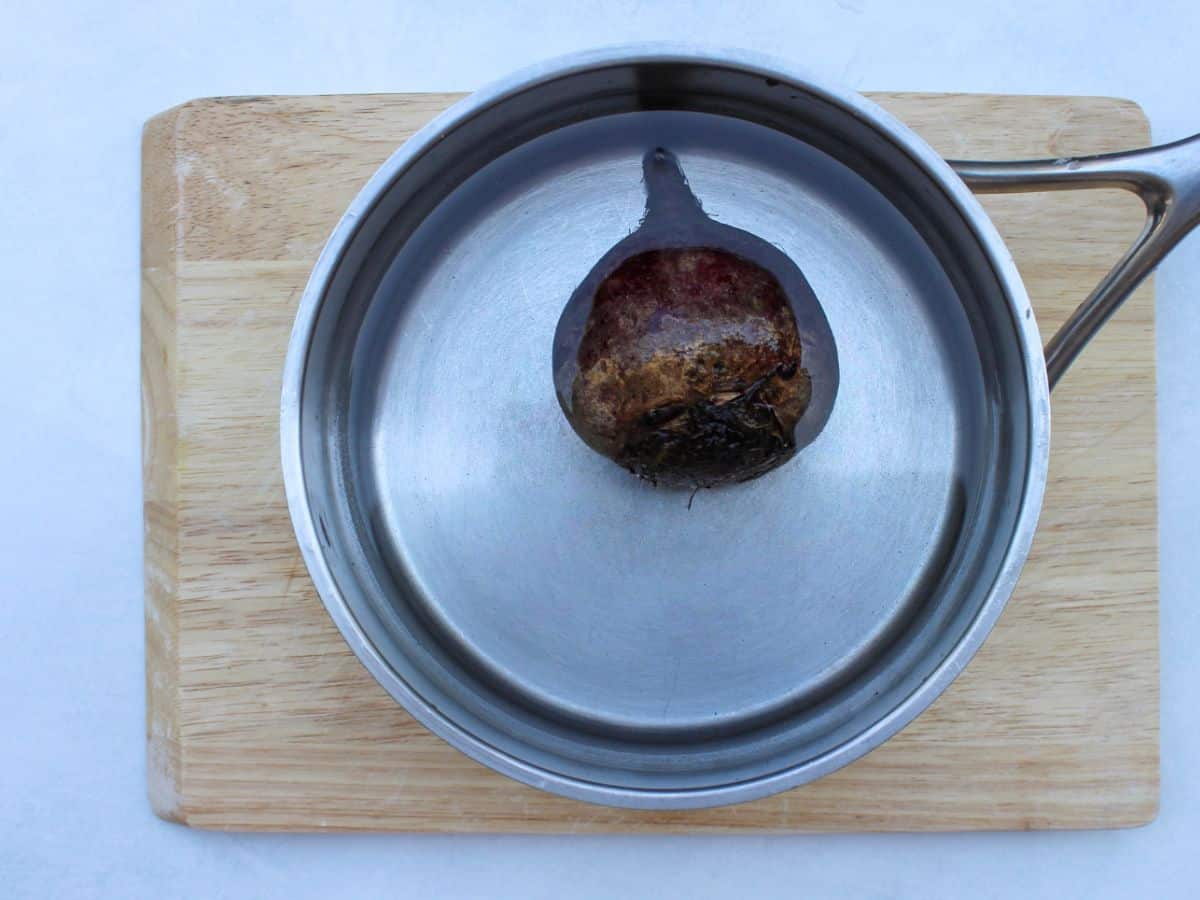 Whole beetroot in a pot with water.