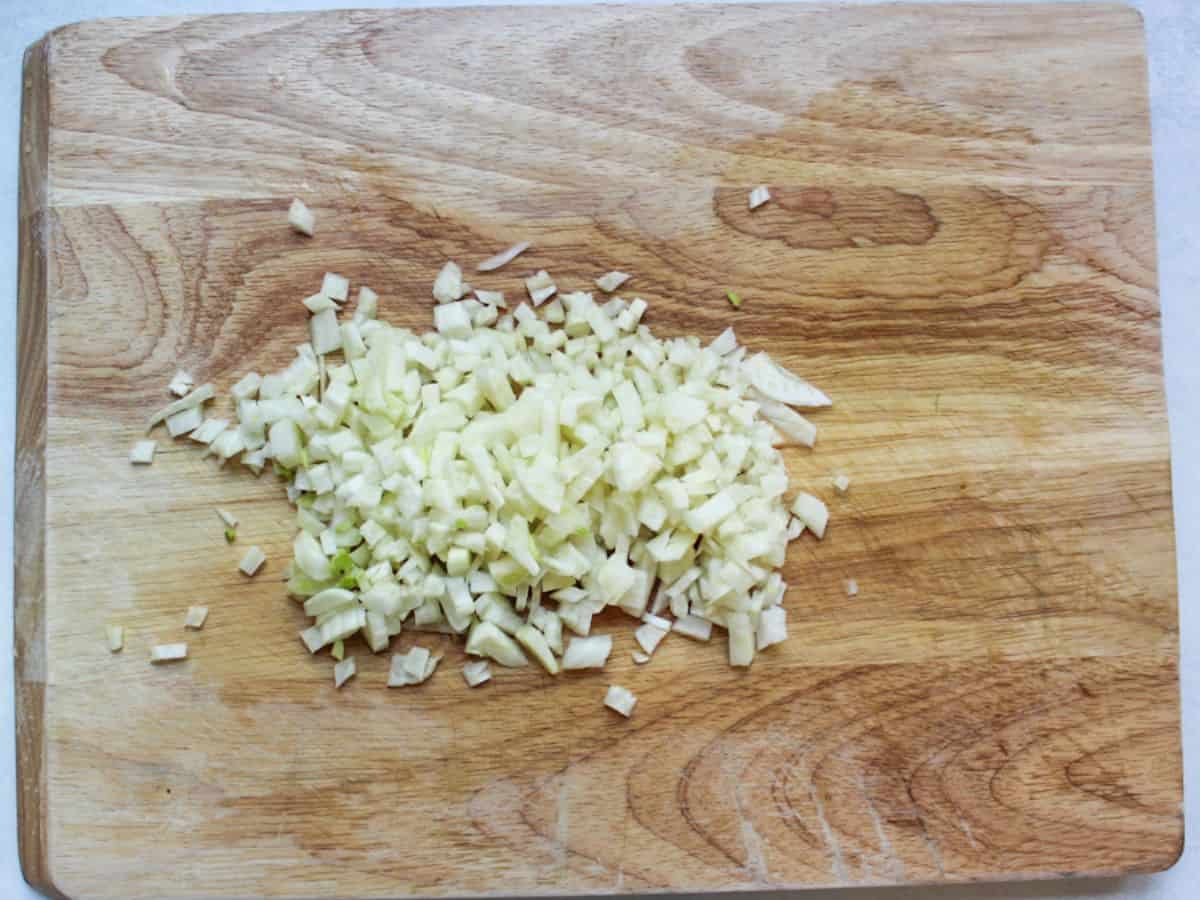 Finely diced fennel on a wooden cutting board.