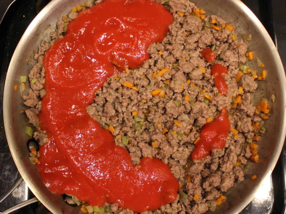Tomato puree added to the browned ground beef.