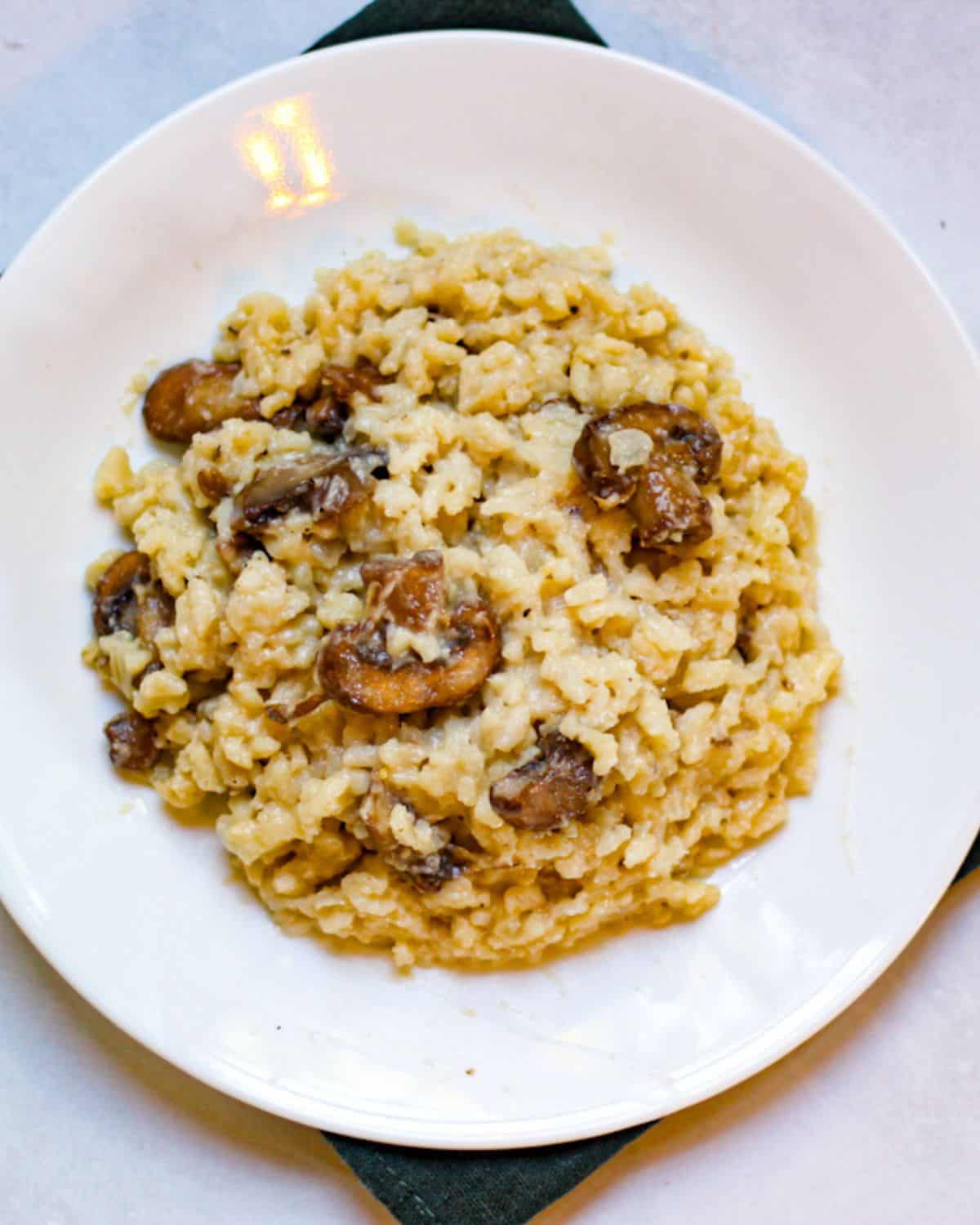 Risotto con funghi served in a white plate. 