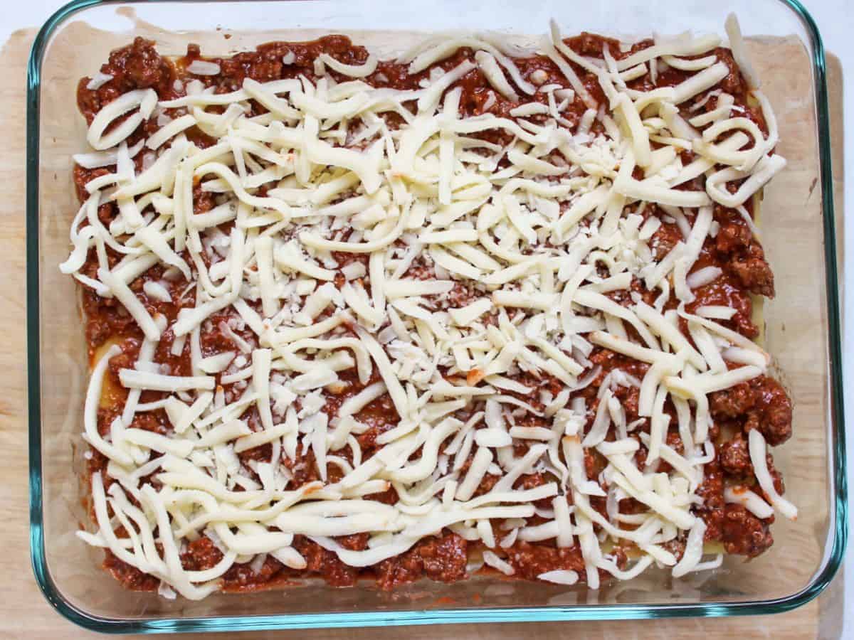 Layer of meat sauce and shredded mozzarella as a top layer of lasagna.