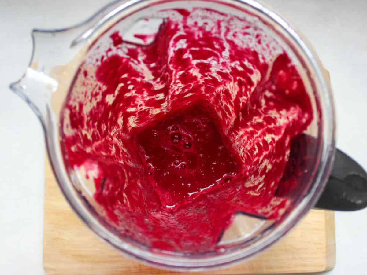 Beetroot blended into a pink puree in a blender.