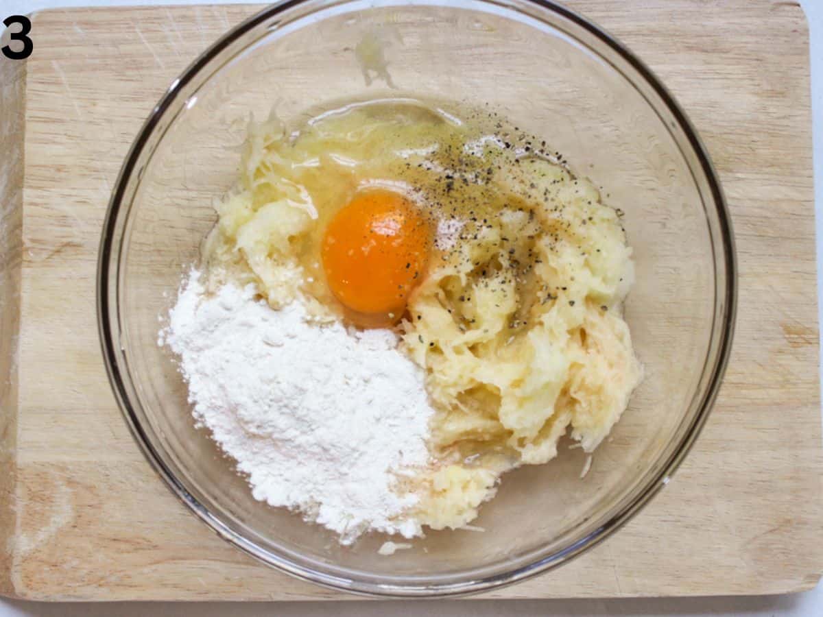 Egg, flour, salt and pepper added to the bowl with the grated potatoes.