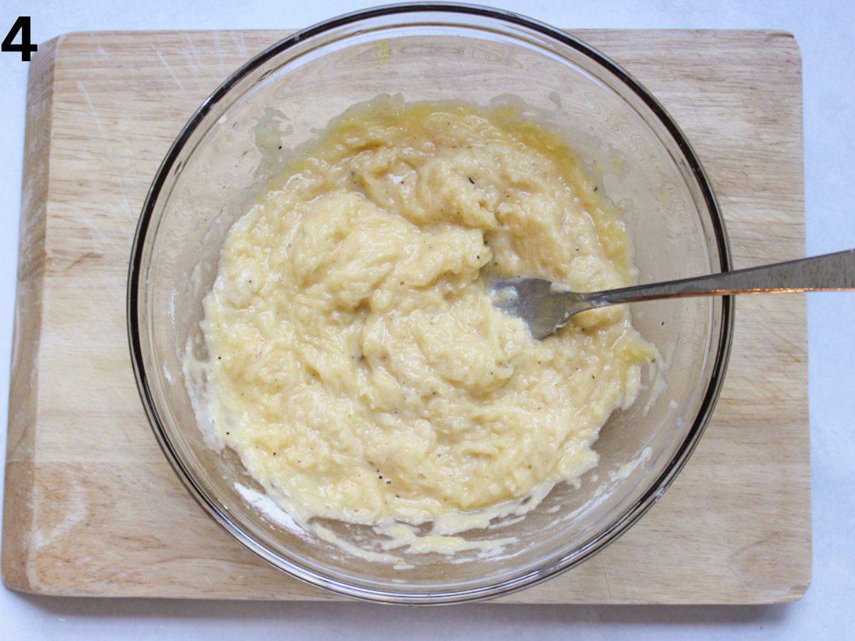 Deruny batter mixed with a fork in a glass bowl.