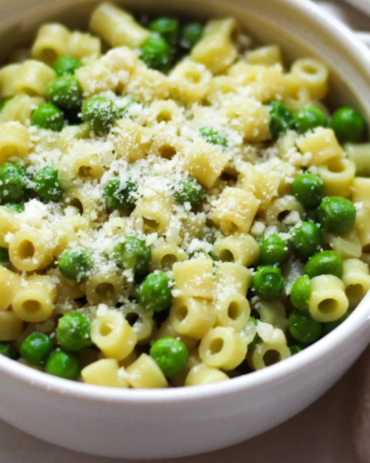 Pasta e piselli with grated Parmesan on top.