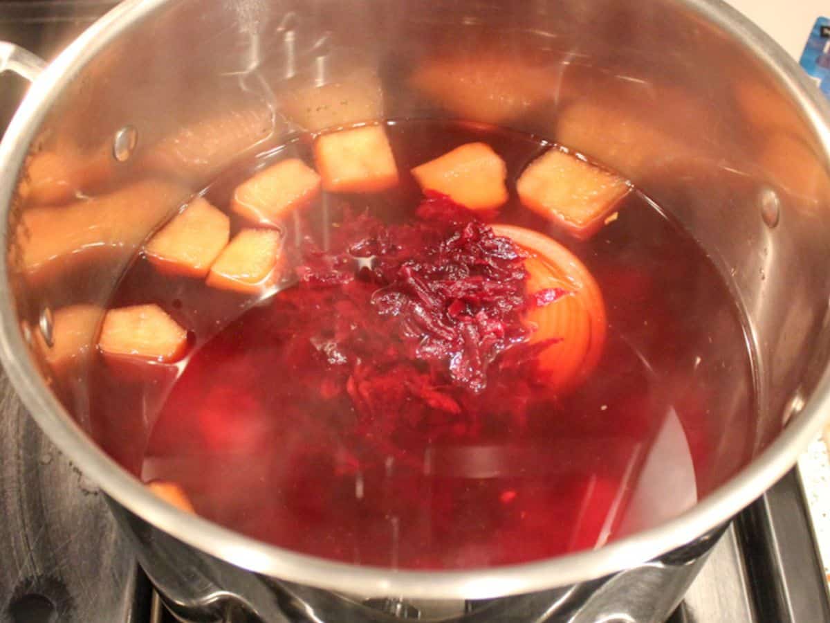 Red beetroot soup with simmering in a large stainless steel pot.