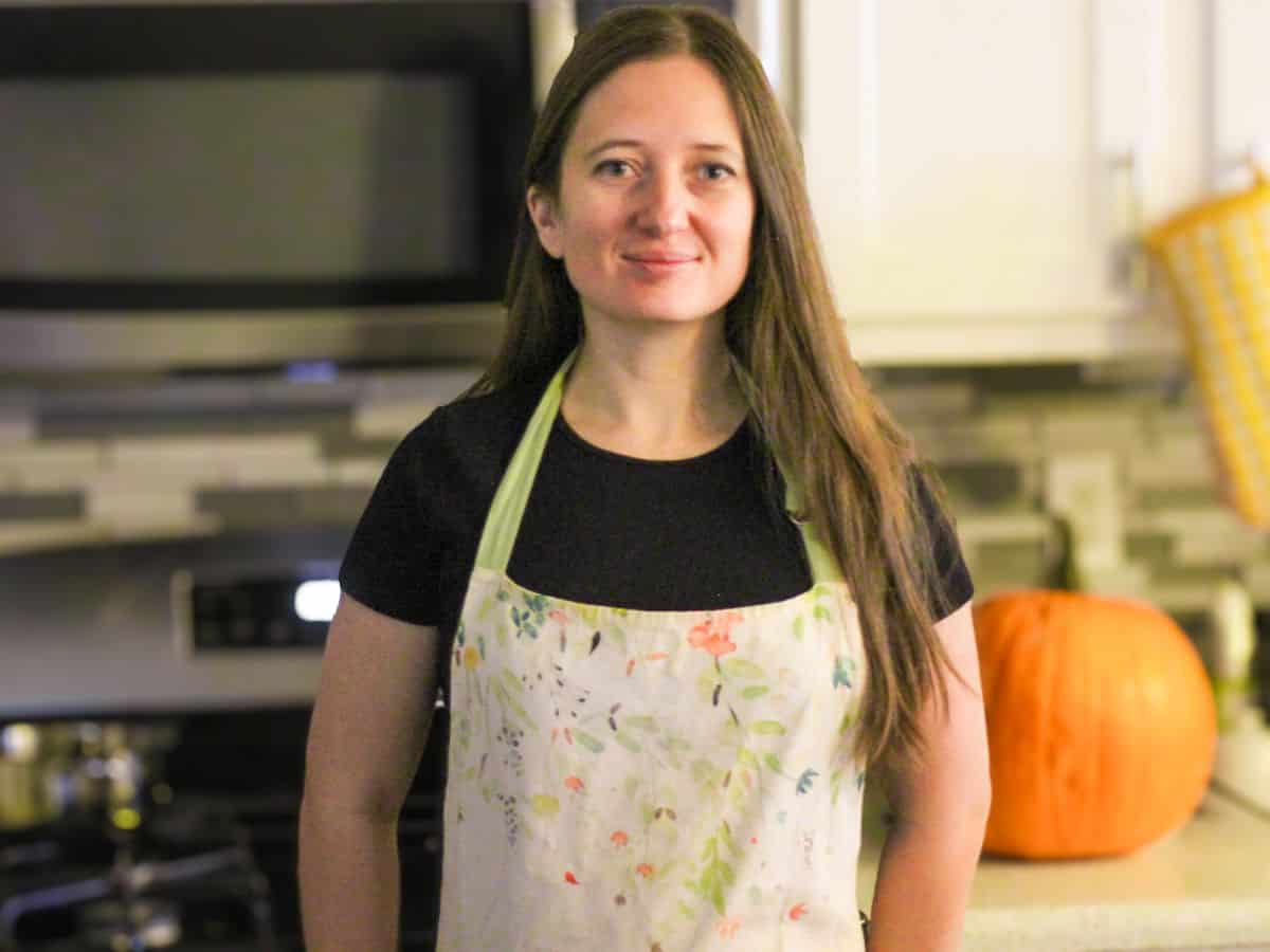 Sava's kitchen female author wearing an apron standing in the kitchen.