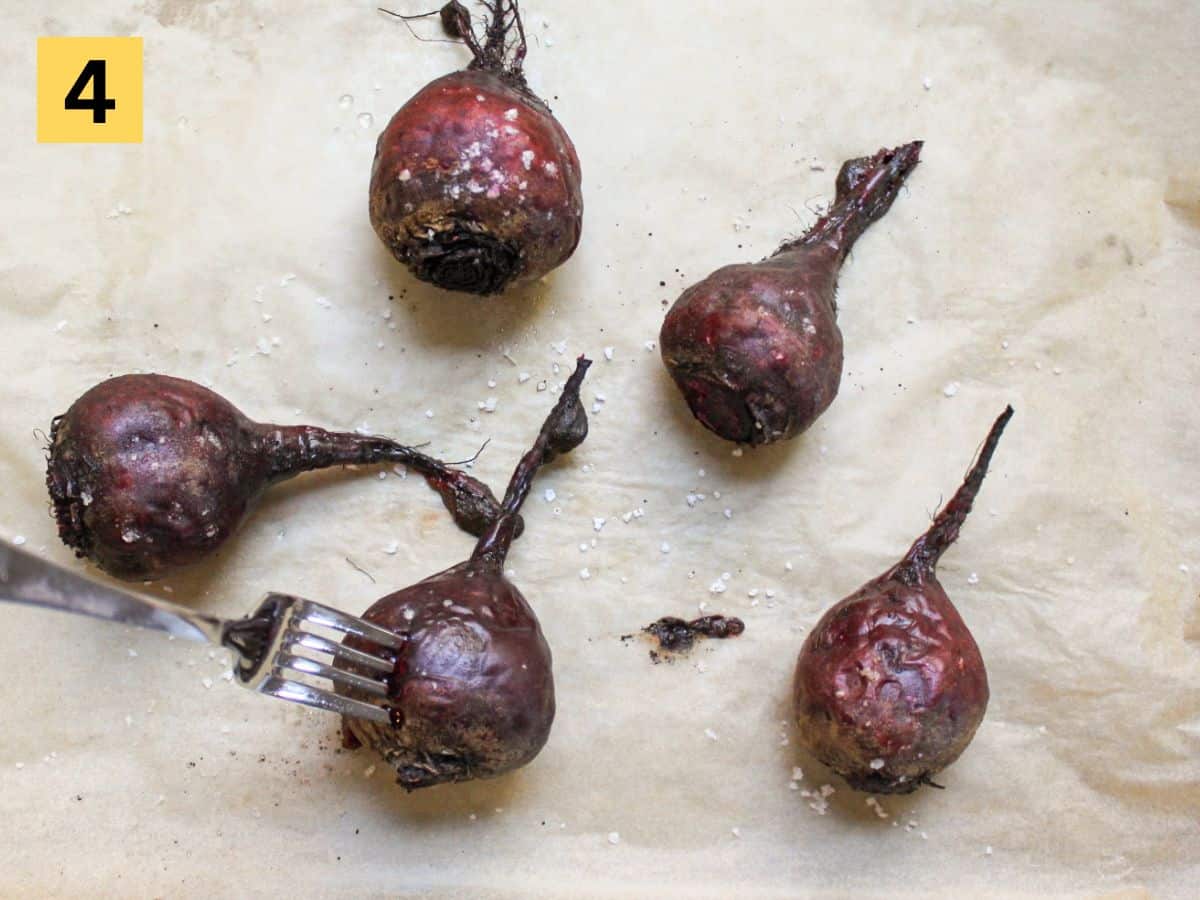 Fork inserted in one of the roasted beets to check doneness.