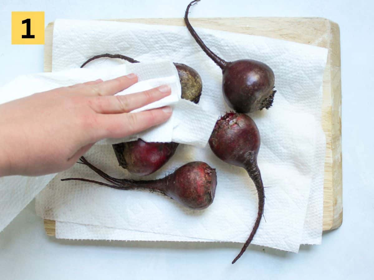 Washed beets being drying with paper towels.