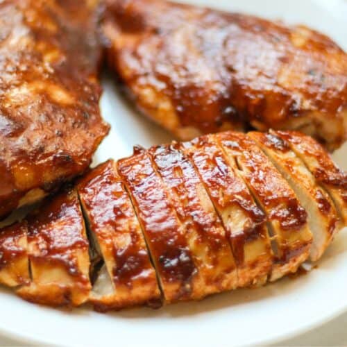 BBQ chicken breast sliced thinly on a plate.