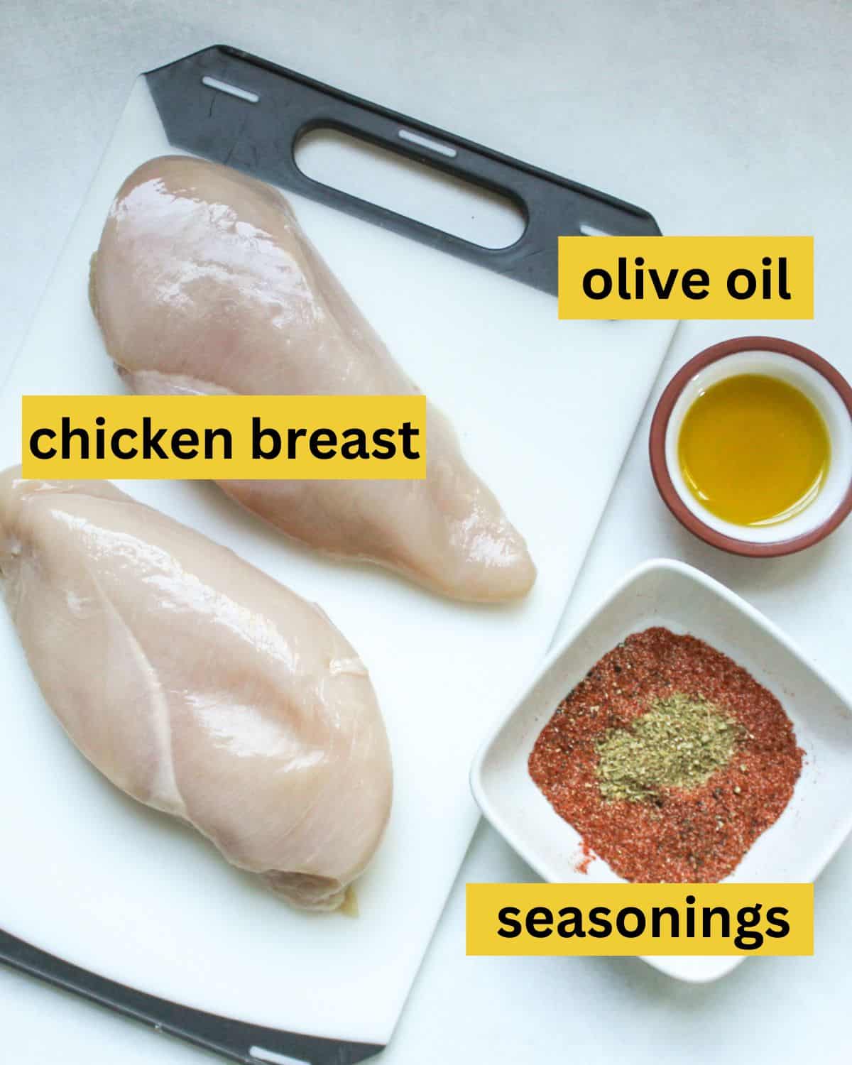 All recipe ingredients arranged on a white background labeled as chicken breast, olive oil, seasonings.