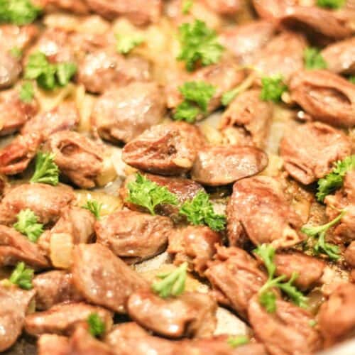 Fried chicken hearts garnished with fresh curly parsley.