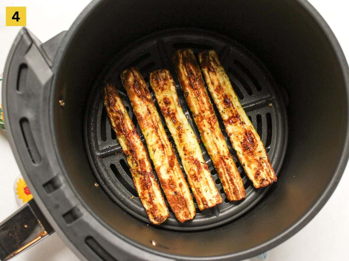 Roasted zucchini in air fryer basket.