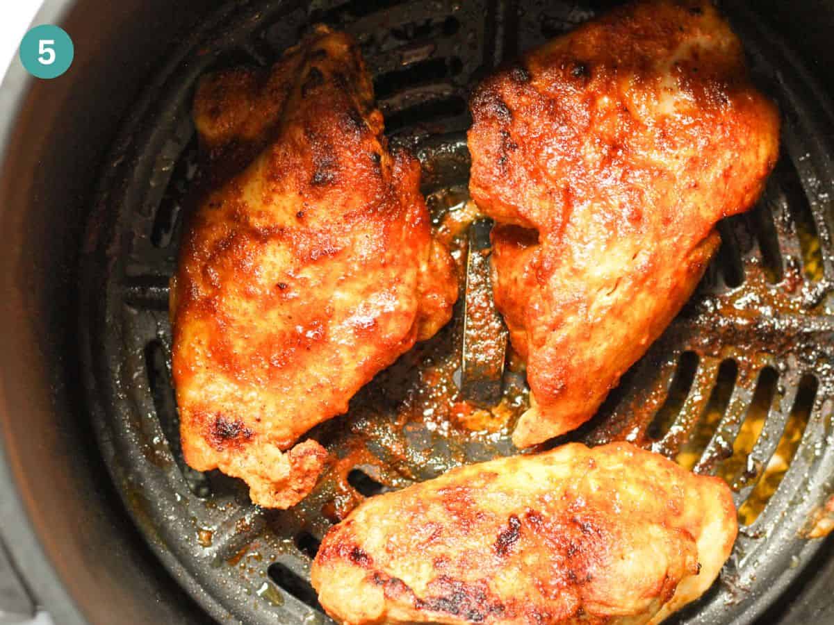 Fully cooked chicken thighs from frozen in air fryer basket.