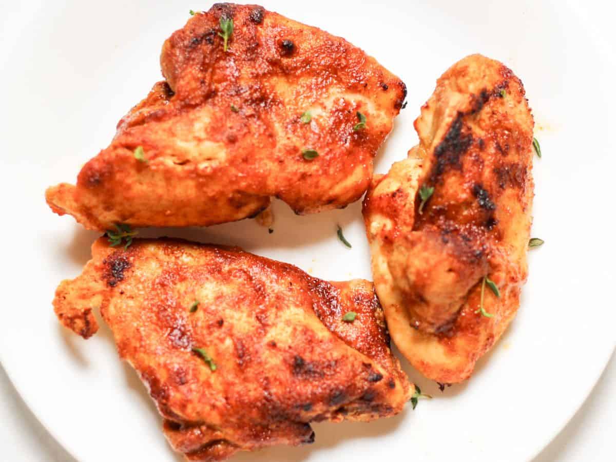 Air fried boneless chicken thighs served on a white plate.