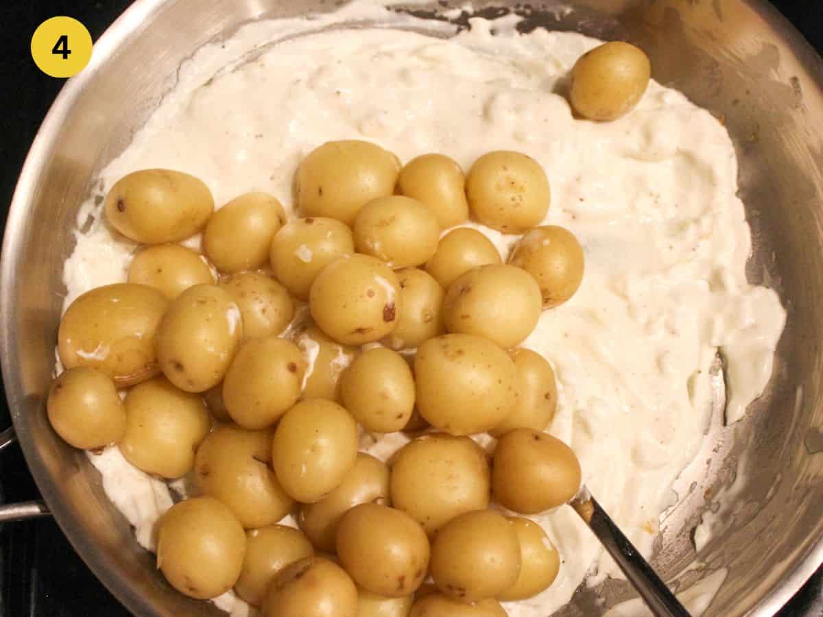 Adding boiled potatoes to the sour cream sauce.