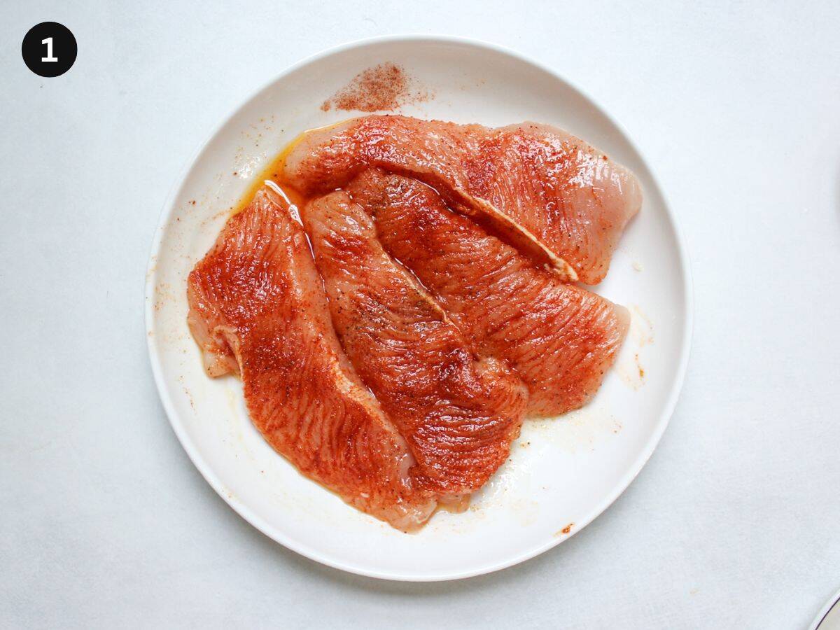 Raw turkey steaks coated in seasonings, salt, and oil.