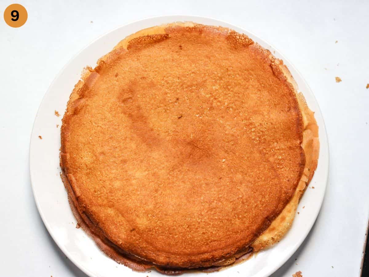 Stacked cooked french-style crepes on white plate. 