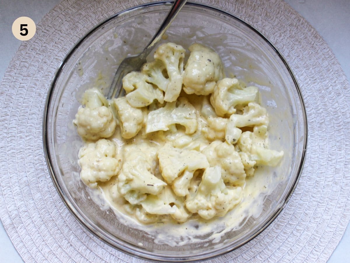 Tossing cauliflower florets in a batter.